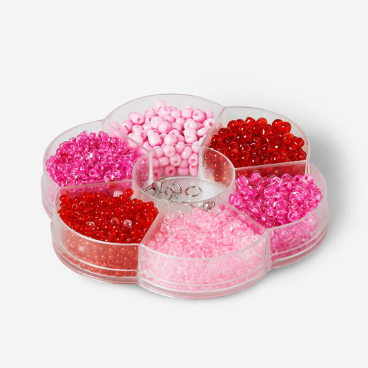 Schachtel mit roten und rosa Glasperlen und Schmuckverschlüssen