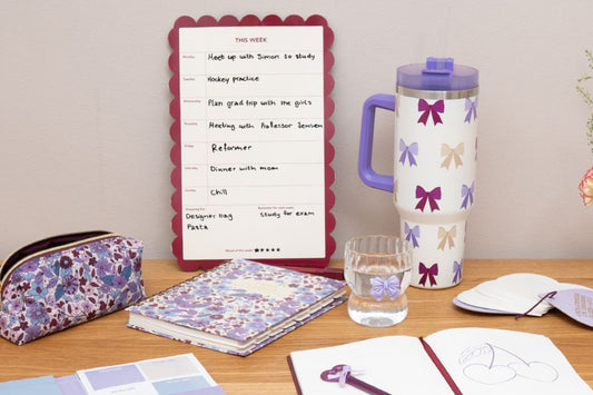 Desk with a planner, water bottle, and stationery items.