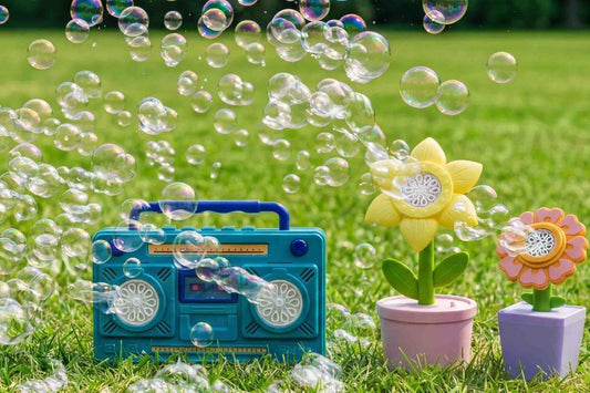 Colorful flowers and a blue radio surrounded by bubbles on green grass.