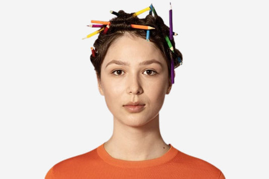 Woman with hair styled using colorful pens, wearing an orange shirt.