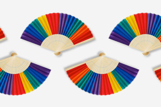 Pride paper fans arranged in a pattern on a light grey background.
