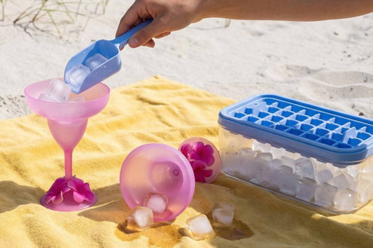 Hand scooping ice into a pink cup on a yellow towel.