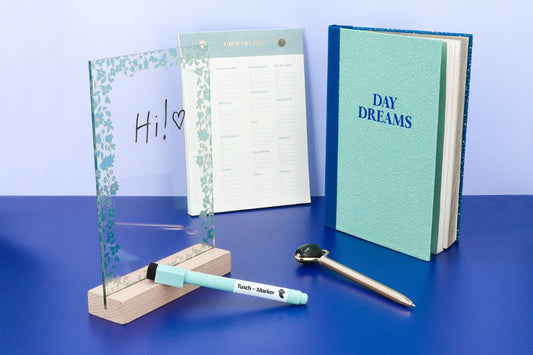 A decorative frame, notebook, planner, pen, and a book titled "Dare to Dream.