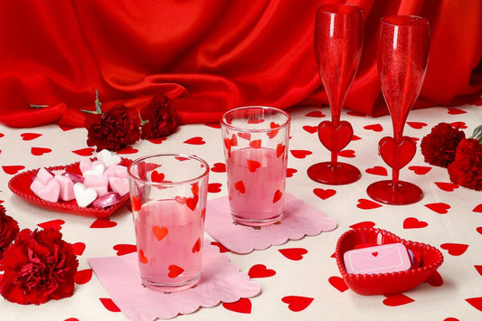 Two drinks with heart decorations on a red-themed table setting.