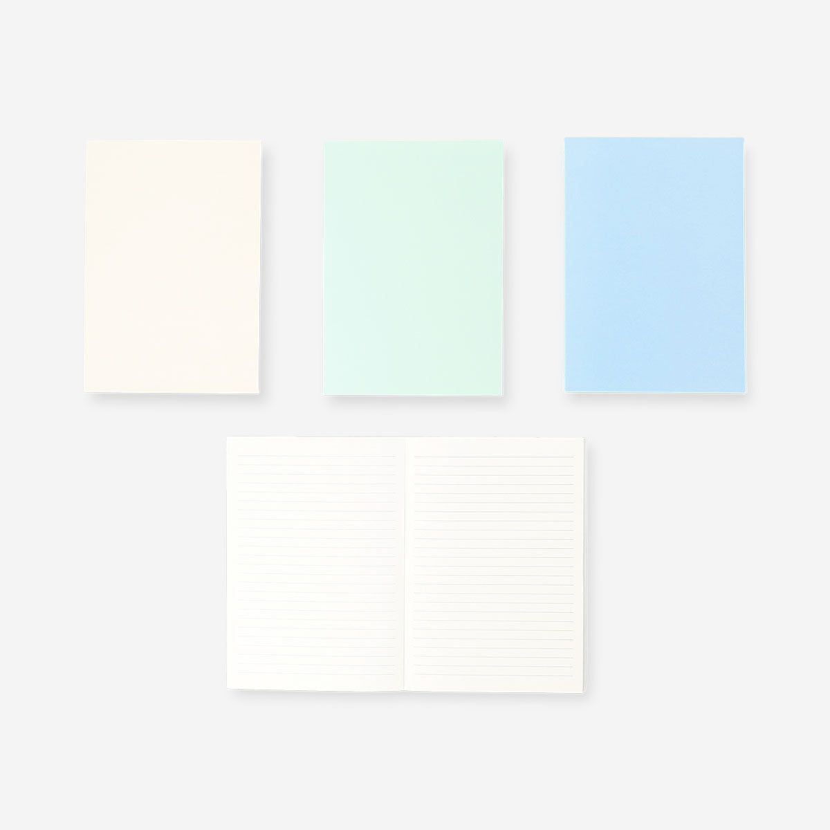 Set of four Flying Tiger Copenhagen A5 solid color office notebooks with vibrant covers and blank pages for note-taking.