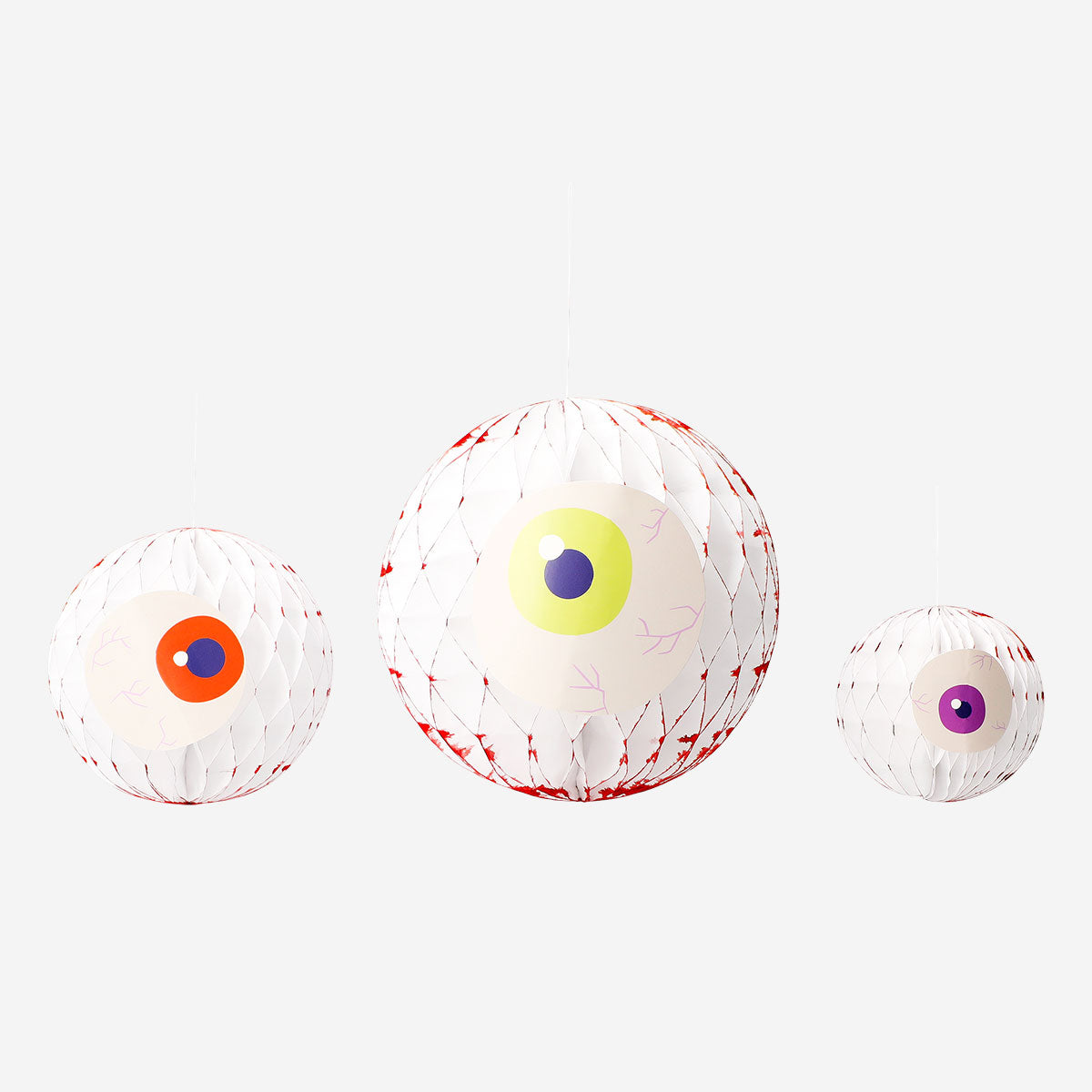Three honeycomb paper eyes decorations for hanging, party decor by Flying Tiger Copenhagen, featuring colorful, textured eye shapes.