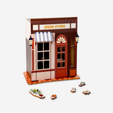 DIY wooden bookstore hobby kit by Flying Tiger Copenhagen, showing assembled miniature wooden bookshelves with small books.