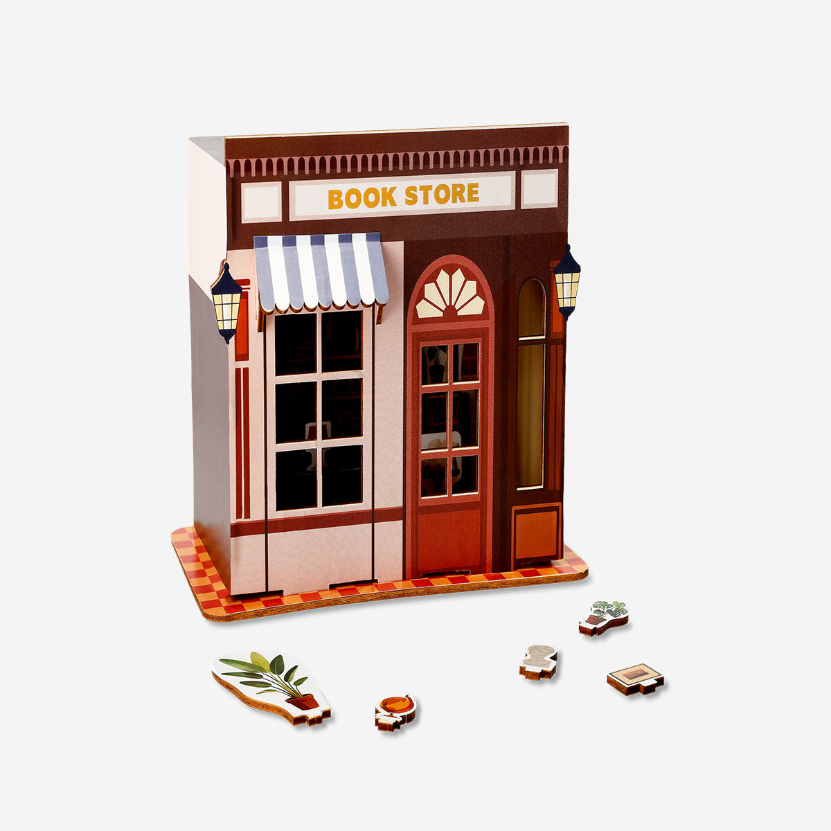 DIY wooden bookstore hobby kit by Flying Tiger Copenhagen, showing assembled miniature wooden bookshelves with small books.