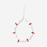 Flying Tiger Copenhagen chili phone charm hanging from a phone, featuring a vibrant red chili design and playful media accessory style.