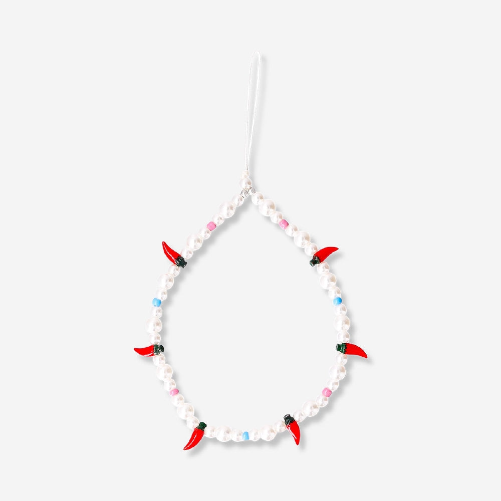 Flying Tiger Copenhagen chili phone charm hanging from a phone, featuring a vibrant red chili design and playful media accessory style.