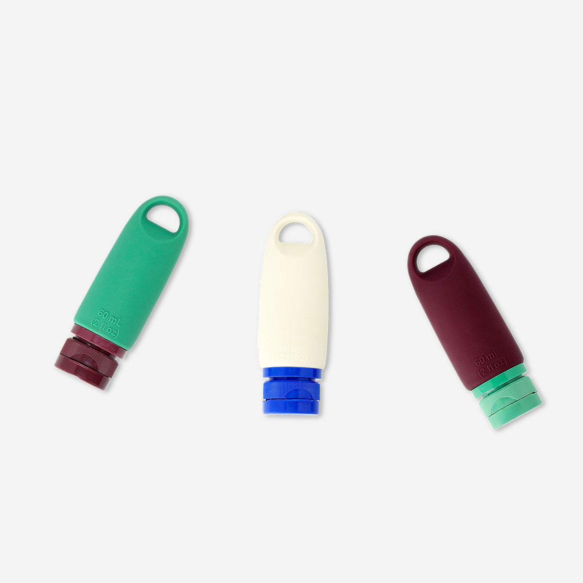 Set of three Flying Tiger Copenhagen silicone travel bottles with hangers for toiletries and liquids, compact and reusable.