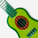 Flying Tiger Copenhagen avocado-shaped ukulele gadget with a green body and four strings, perfect for musical fun and novelty.