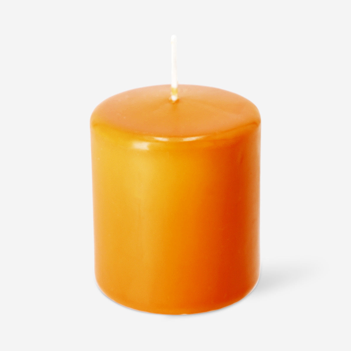 Orange pillar candle from Flying Tiger Copenhagen, 8 cm tall, shown burning with a warm, cozy glow for home decor.