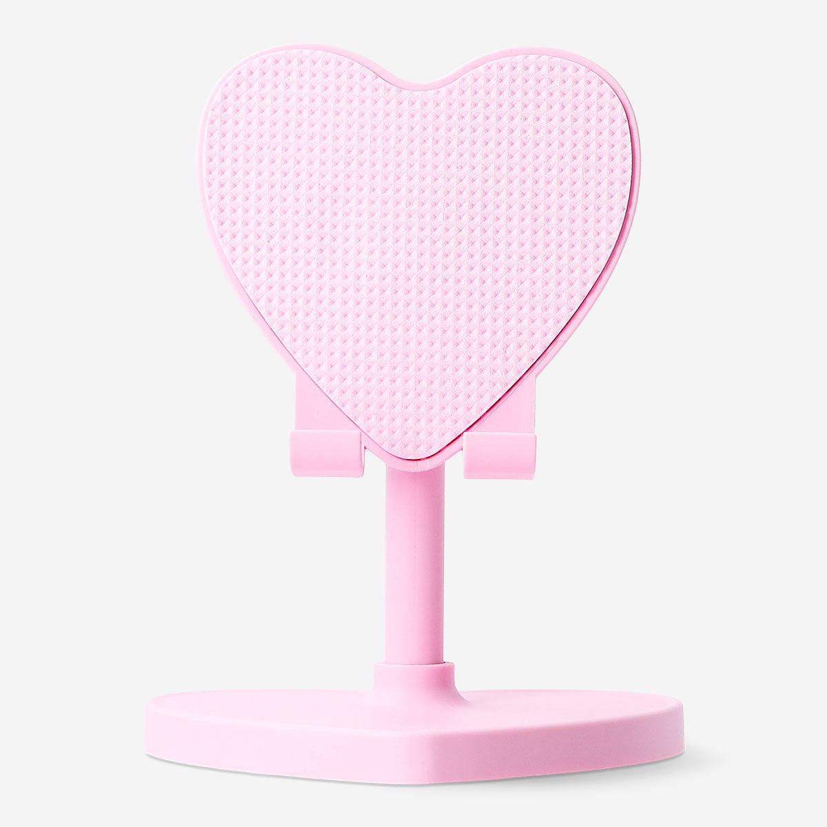 Pink heart-shaped Flying Tiger Copenhagen media smartphone stand resting on a desk with a phone placed on it.