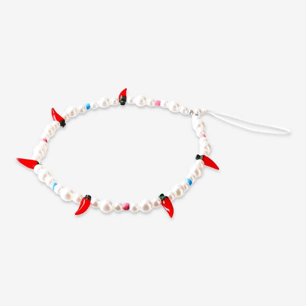 Flying Tiger Copenhagen chilli phone charm hanging from a smartphone, featuring a colorful, playful design.