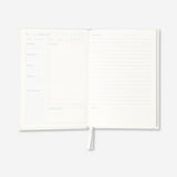 Flying Tiger Copenhagen office recipe book open to colorful pages with recipes and kitchen tips.