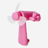 Pink handheld fan gadget by Flying Tiger Copenhagen, compact design with a colorful, portable fan for personal cooling.