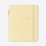 Butter yellow office notebook with a matching ballpoint pen from Flying Tiger Copenhagen, featuring a smooth cover and writing accessories.