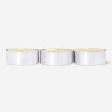 Set of four gold tealight candles for home decoration from Flying Tiger Copenhagen, arranged in a cluster on a neutral surface.