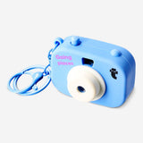 Flying Tiger Copenhagen mini projector camera gadget showing compact design with lens and controls on a plain background.
