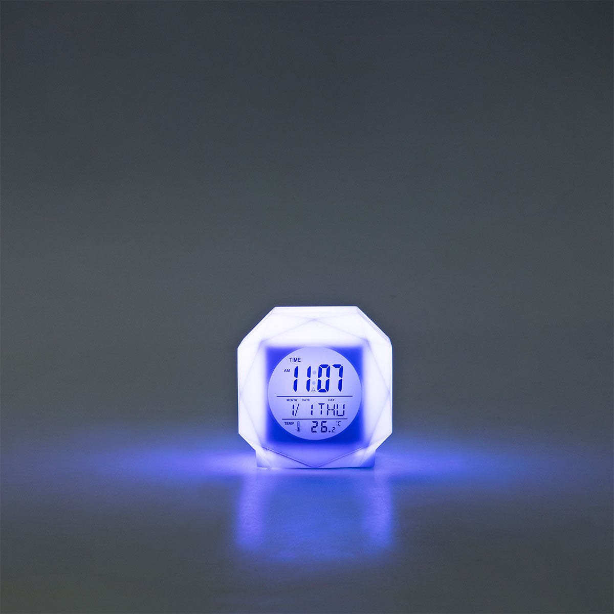 Flying Tiger Copenhagen color-changing digital alarm clock displaying time with a sleek gadget design in a modern setting.