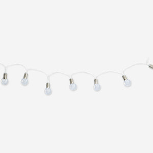 Outdoor string lights with clear bulbs from Flying Tiger Copenhagen, showing a close-up of the glowing, transparent bulbs on a home patio.