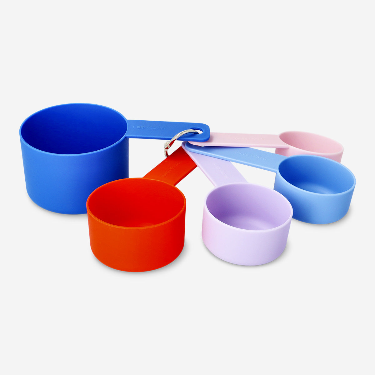 Set of four Flying Tiger Copenhagen designer collection measuring cups for kitchen use, with clear measurement markings.