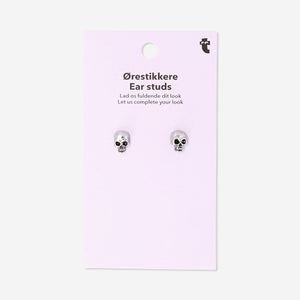 Silver skull stud earrings from Flying Tiger Copenhagen with textile backing, featuring small, detailed skull designs.