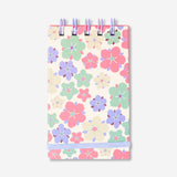 Spiral-bound floral office notebook by Flying Tiger Copenhagen with colorful floral cover and lined pages inside.