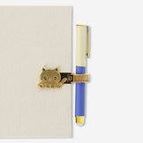 Gold cat pen loop from Flying Tiger Copenhagen, designed to attach to notebooks or planners for easy pen access.