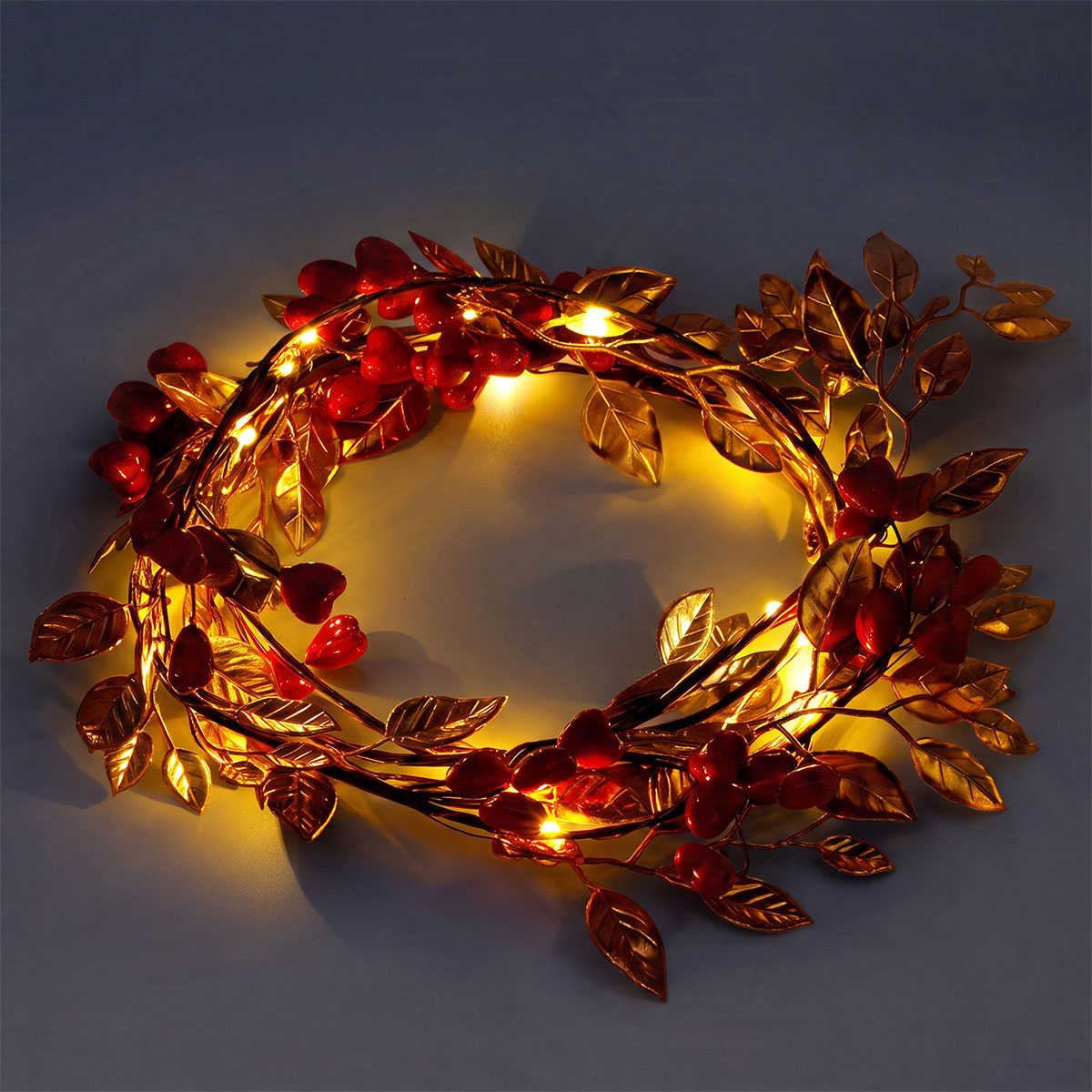 String lights with red berries and gold leaves, decorative home lighting by Flying Tiger Copenhagen, ideal for festive or cozy decor.