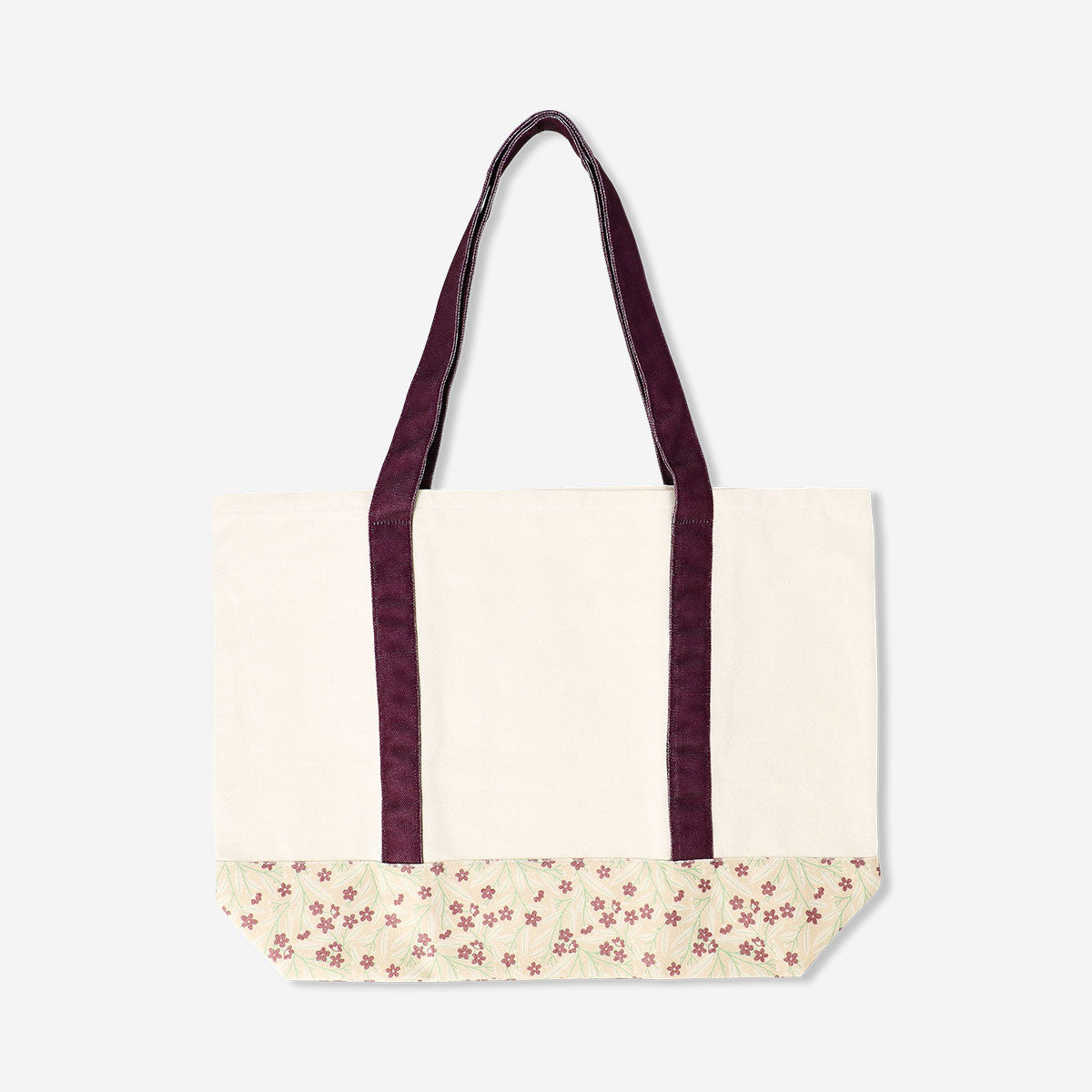 Textile shopper bag with floral pattern and burgundy strap from Flying Tiger Copenhagen, showing the bag's design and handles.