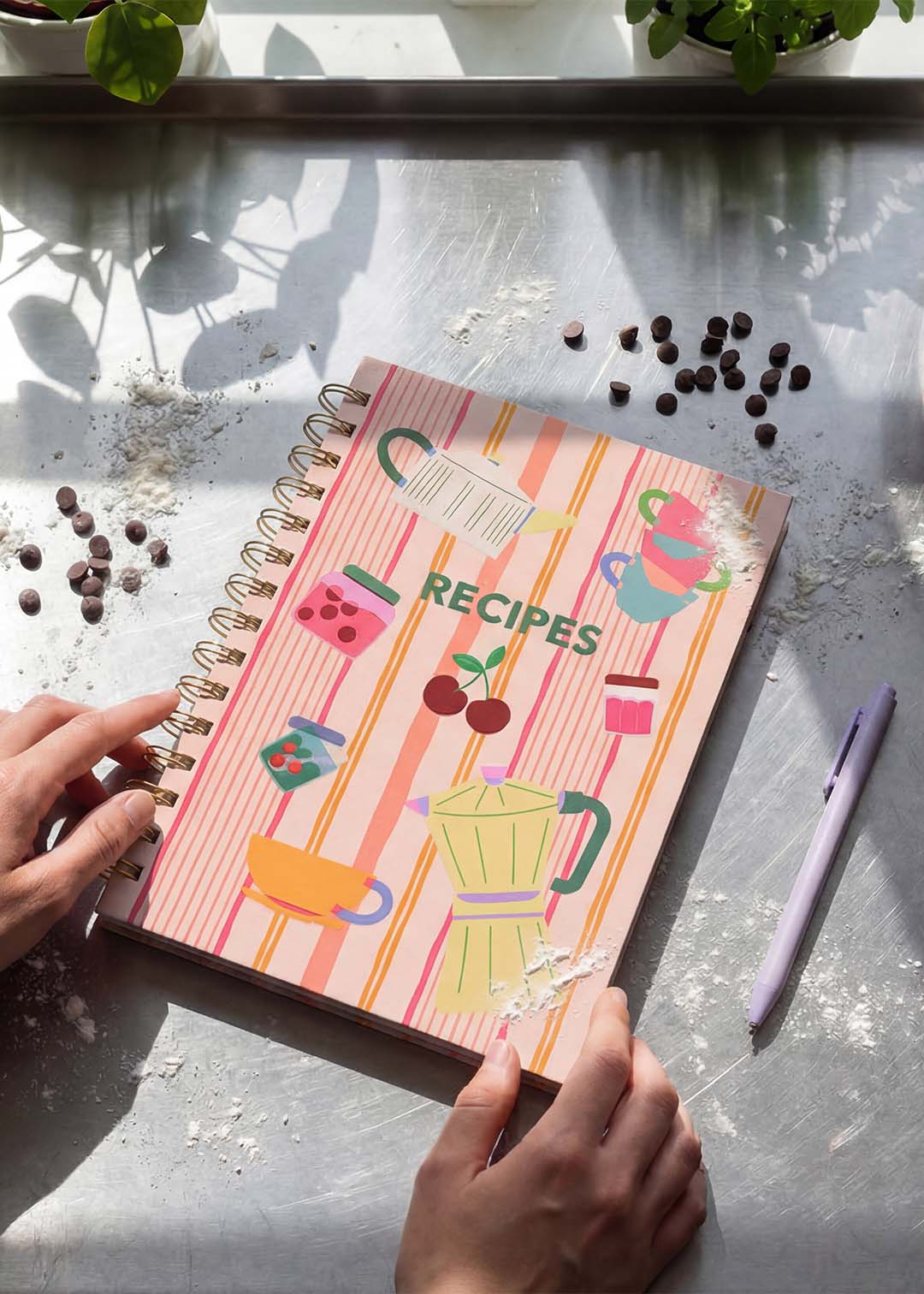 Flying Tiger Copenhagen office recipe book open to pages with colorful cooking and baking ideas, laid out on a desk.