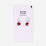 Red heart-shaped textile earrings with spike details hanging from silver hooks, stylish and playful accessory.