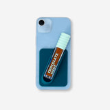 Blue lip gloss holder for phone cover, branded Flying Tiger Copenhagen, featuring a decorative lip gloss design.