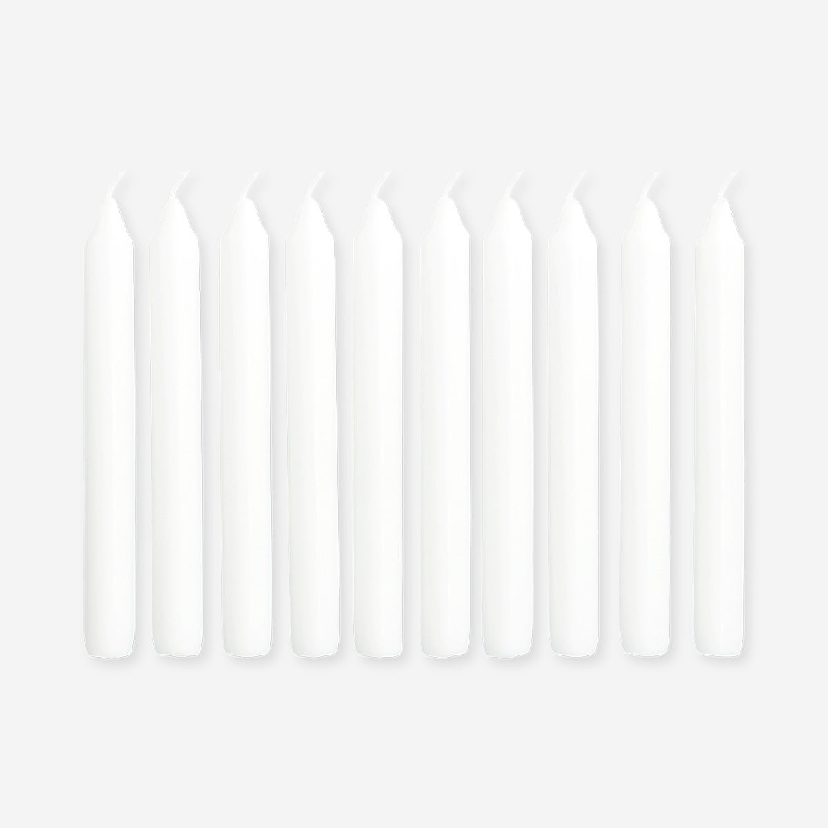 Set of three white dinner candles from Flying Tiger Copenhagen, 10-piece home candle set on a clean surface.