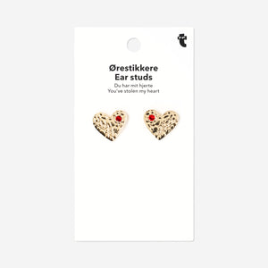 Red rhinestone heart-shaped textile ear studs from Flying Tiger Copenhagen, shown close-up on a white background.