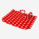 Red textile tote bag with heart patterns from Flying Tiger Copenhagen, featuring sturdy handles and vibrant design.