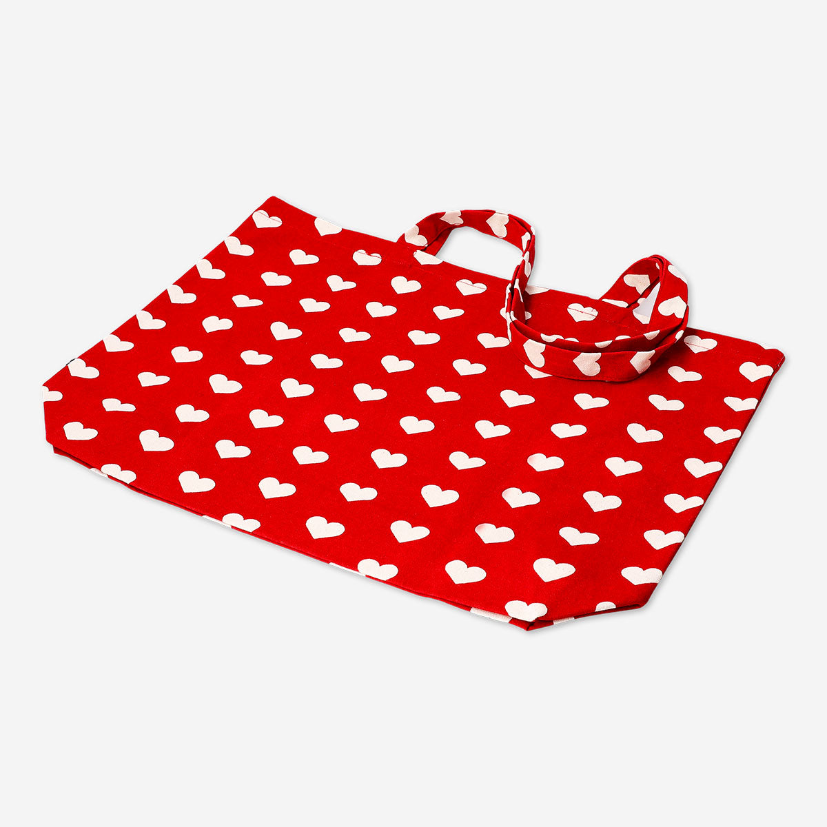 Red textile tote bag with heart patterns from Flying Tiger Copenhagen, featuring sturdy handles and vibrant design.