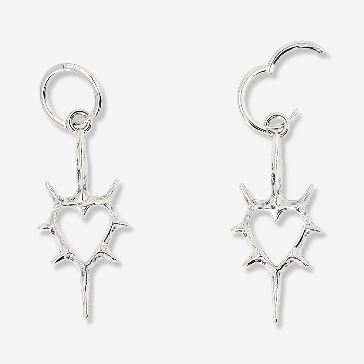 Silver heart-shaped hanging earrings with spiky textile design from Flying Tiger Copenhagen, featuring a modern and edgy jewelry style.