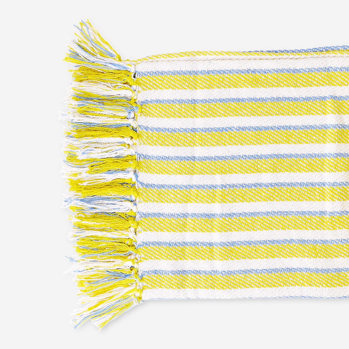 Yellow striped throw blanket with fringes, 120x170 cm, from Flying Tiger Copenhagen, shown draped on a cozy living room sofa.