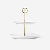 Two-tier Flying Tiger Copenhagen kitchen cake stand with white ceramic plates and metal frame, ideal for serving desserts or snacks.