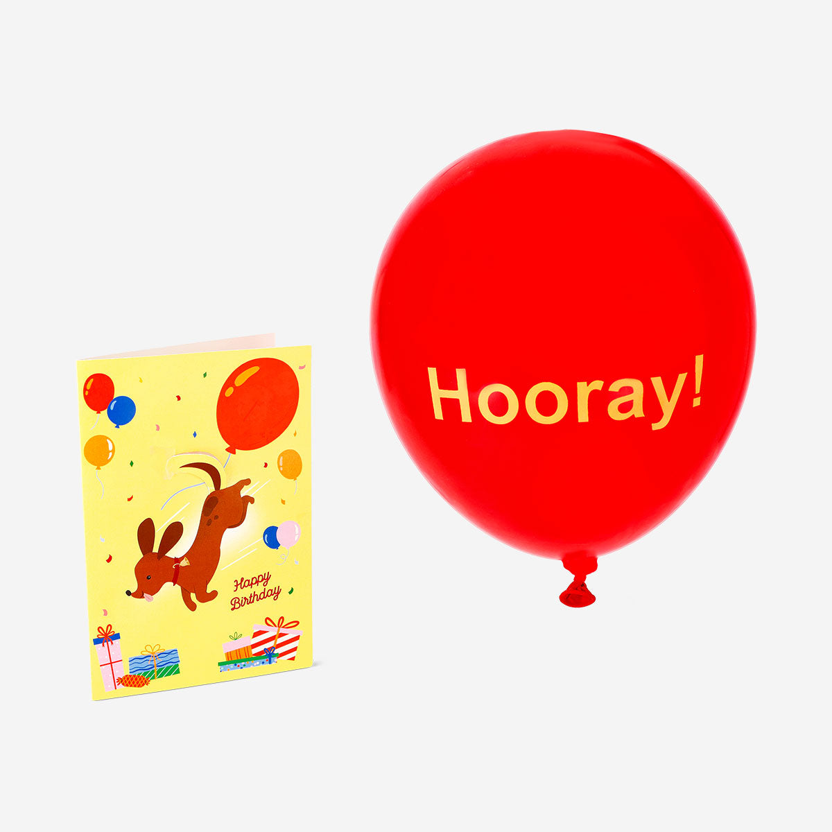 Office birthday card featuring a sausage dog holding a balloon, from Flying Tiger Copenhagen, with colorful design and cheerful illustration.