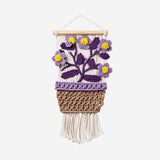 Flying Tiger Copenhagen floral macramé kit for hanging decor, includes colorful cords and instructions for creating floral designs.