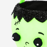 Green zombie trick or treat bucket for Halloween party, featuring spooky zombie design by Flying Tiger Copenhagen