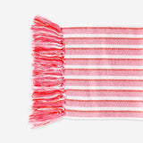 Pink striped throw blanket with fringes, 120x170 cm, from Flying Tiger Copenhagen, displayed on a cozy home setting.