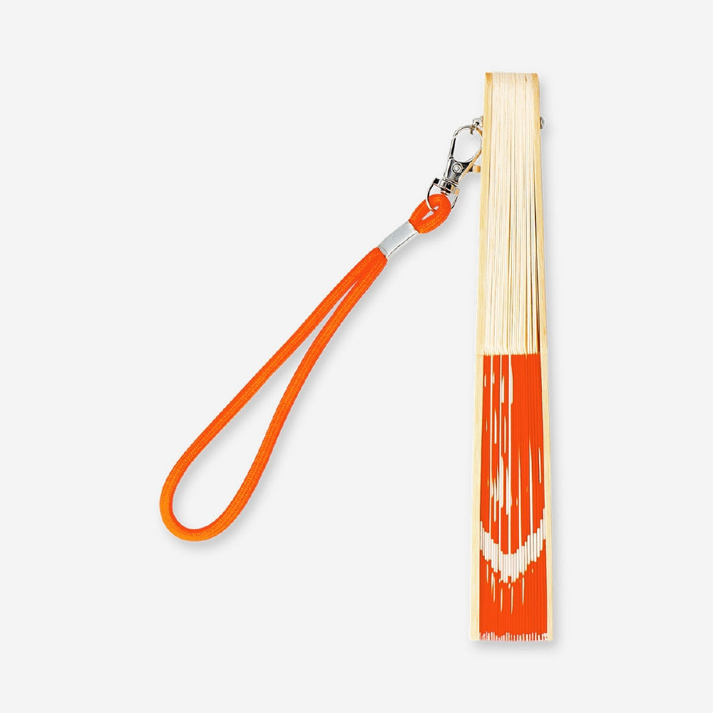 Foldable bamboo fan with orange printed textile surface and strap, stylish portable accessory by Flying Tiger Copenhagen.
