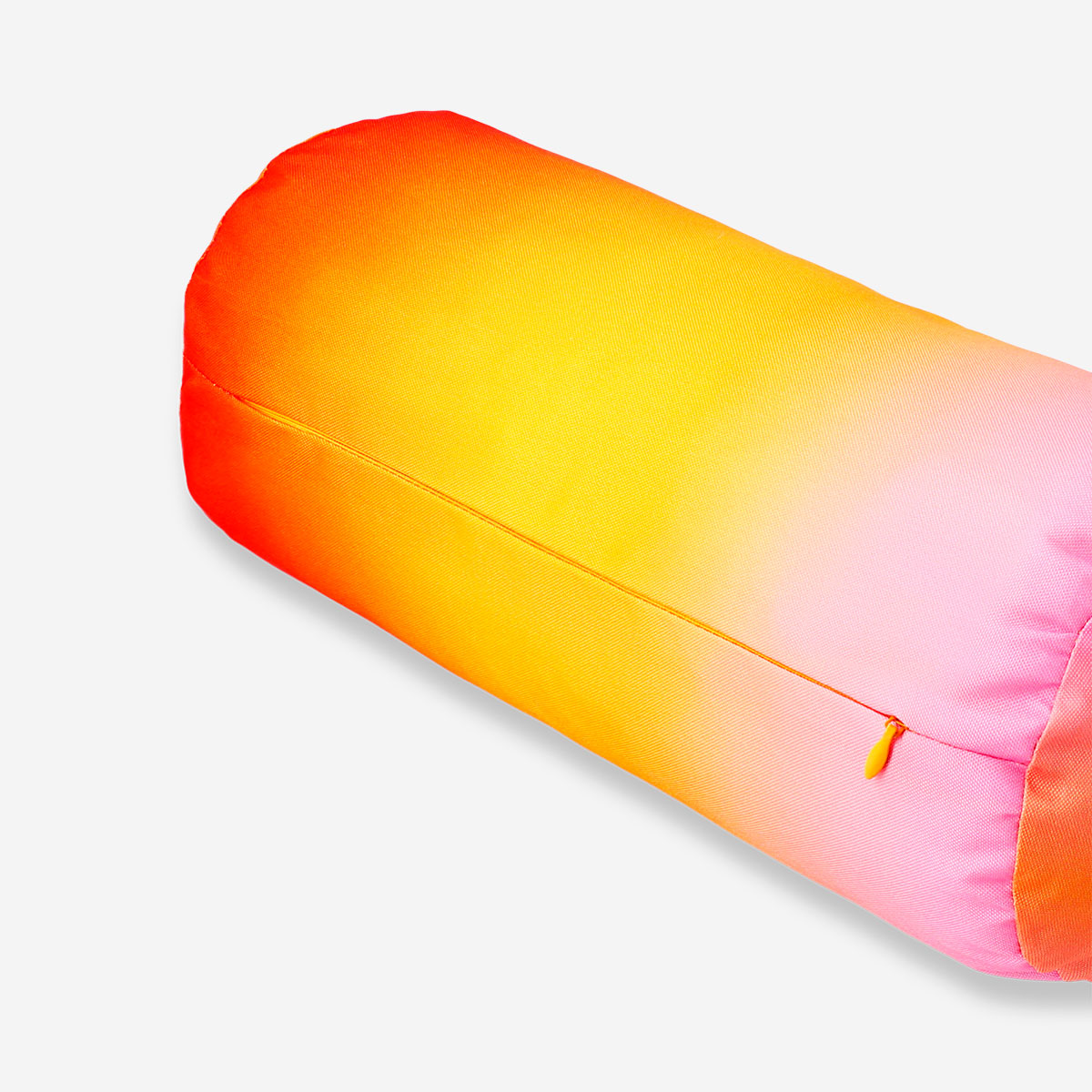 Colorful gradient bolster cushion from Flying Tiger Copenhagen, soft and decorative home accessory on a modern sofa.