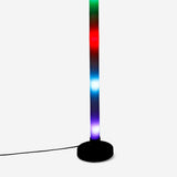 Color-changing LED tube gadget by Flying Tiger Copenhagen, glowing with vibrant multicolor light in a close-up shot.