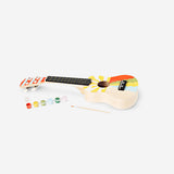 DIY ukulele kit with paint from Flying Tiger Copenhagen, featuring a wooden ukulele and colorful paint supplies for customization.